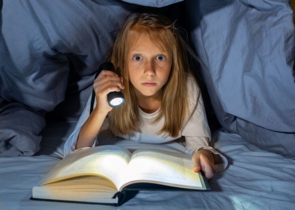 A little girl reading a scary story.